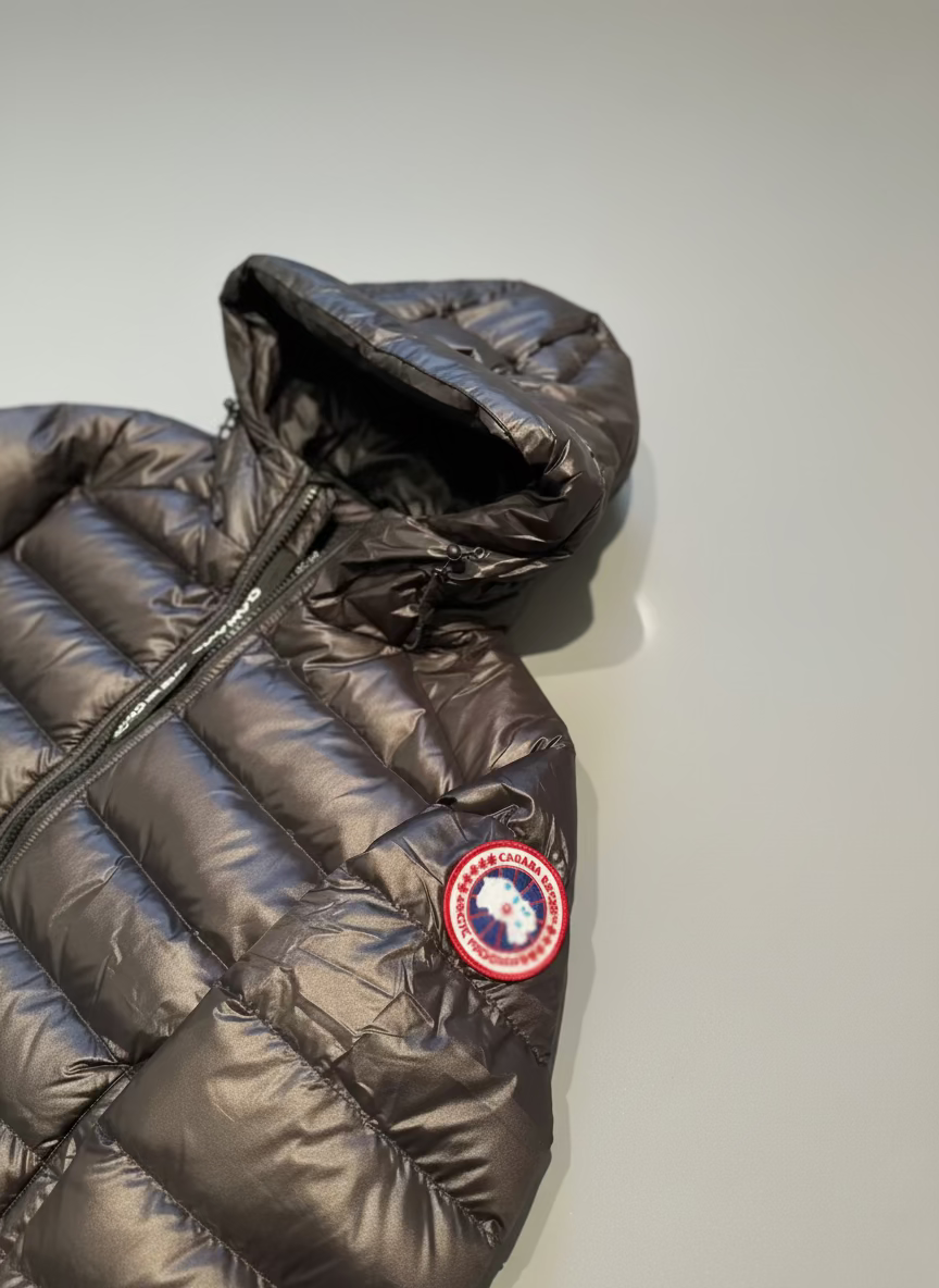 Black puffer jacket with a red and white logo on a textured surface