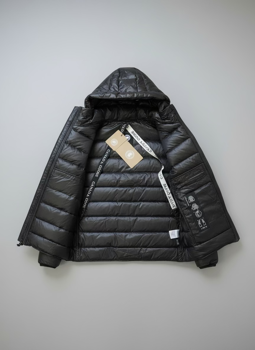 Black puffer jacket with a brand tag on a gray surface
