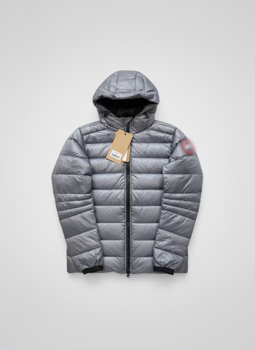 Silver puffer jacket with a tag on a brown surface