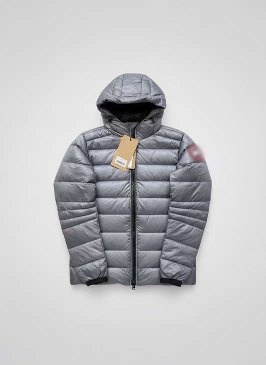 Silver puffer jacket with a tag on a brown surface